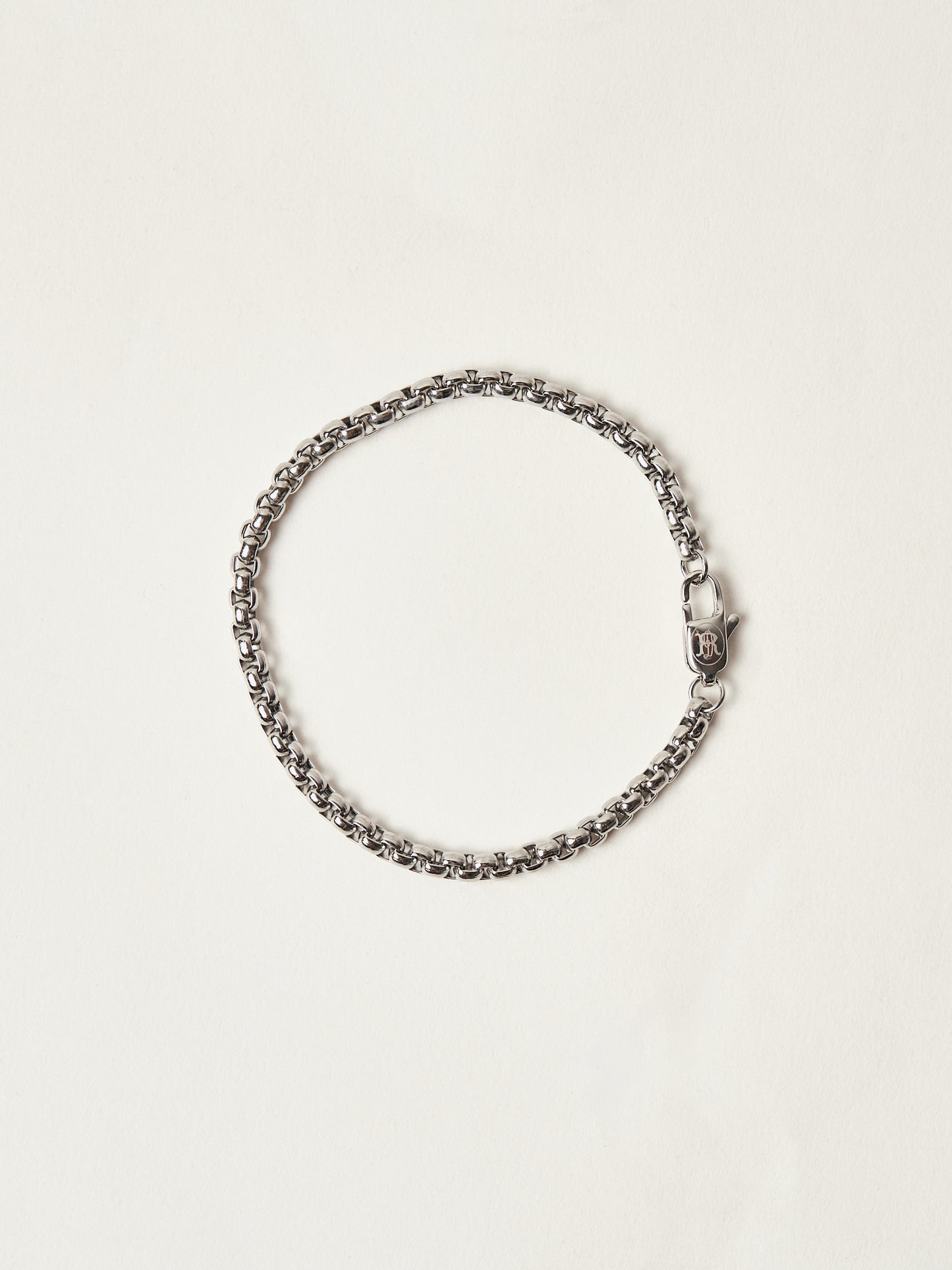 Silver chain bracelet on a light beige background