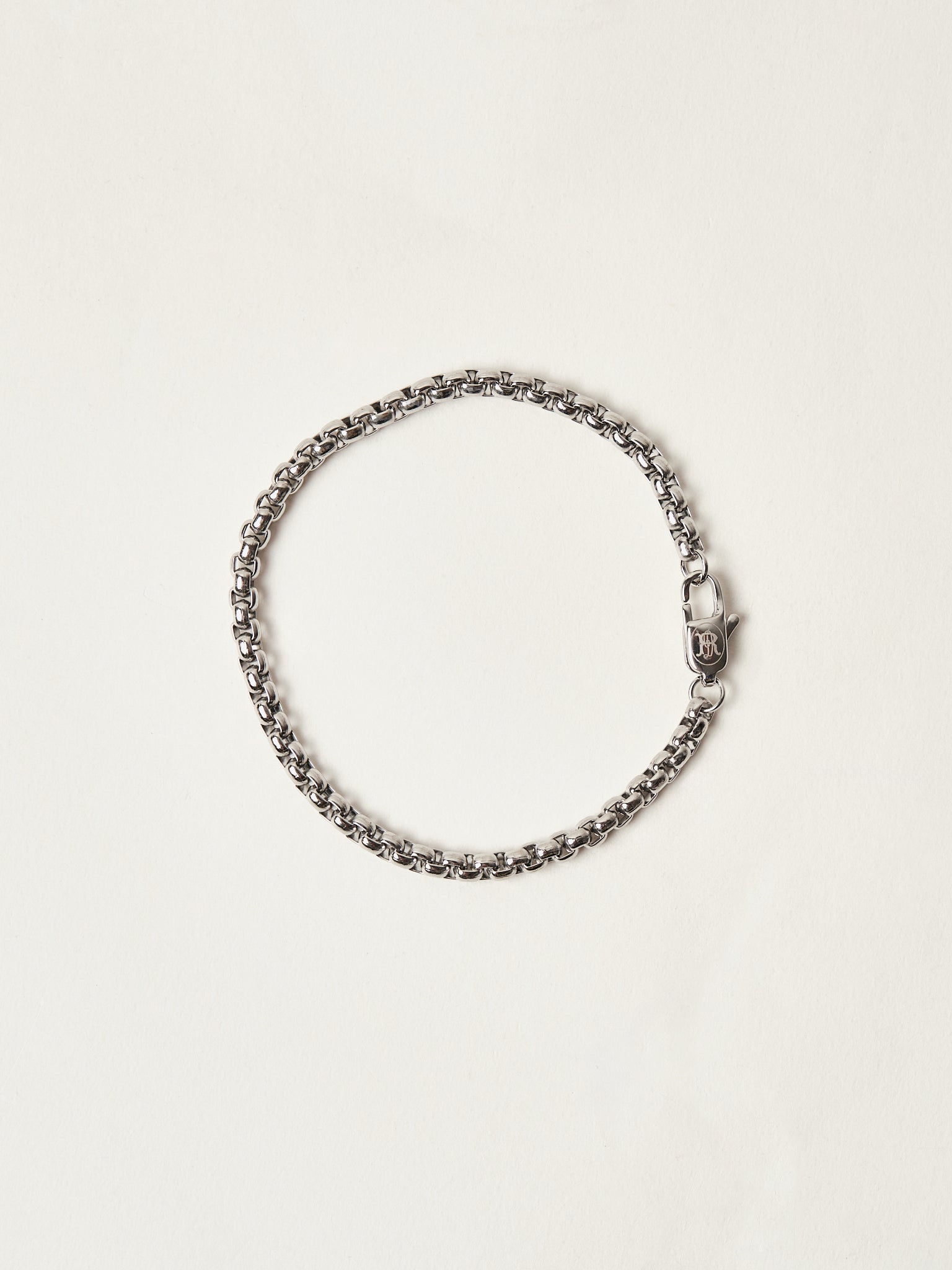 Silver chain bracelet on a light beige background
