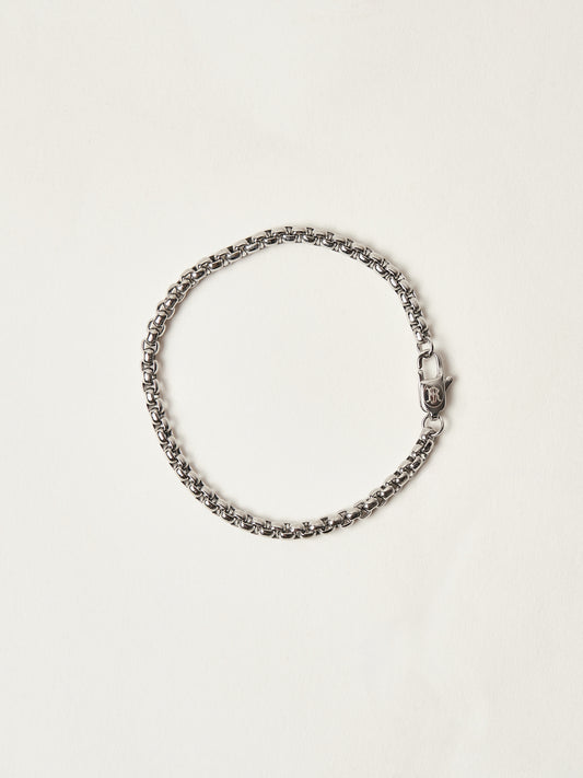 Silver chain bracelet on a light beige background