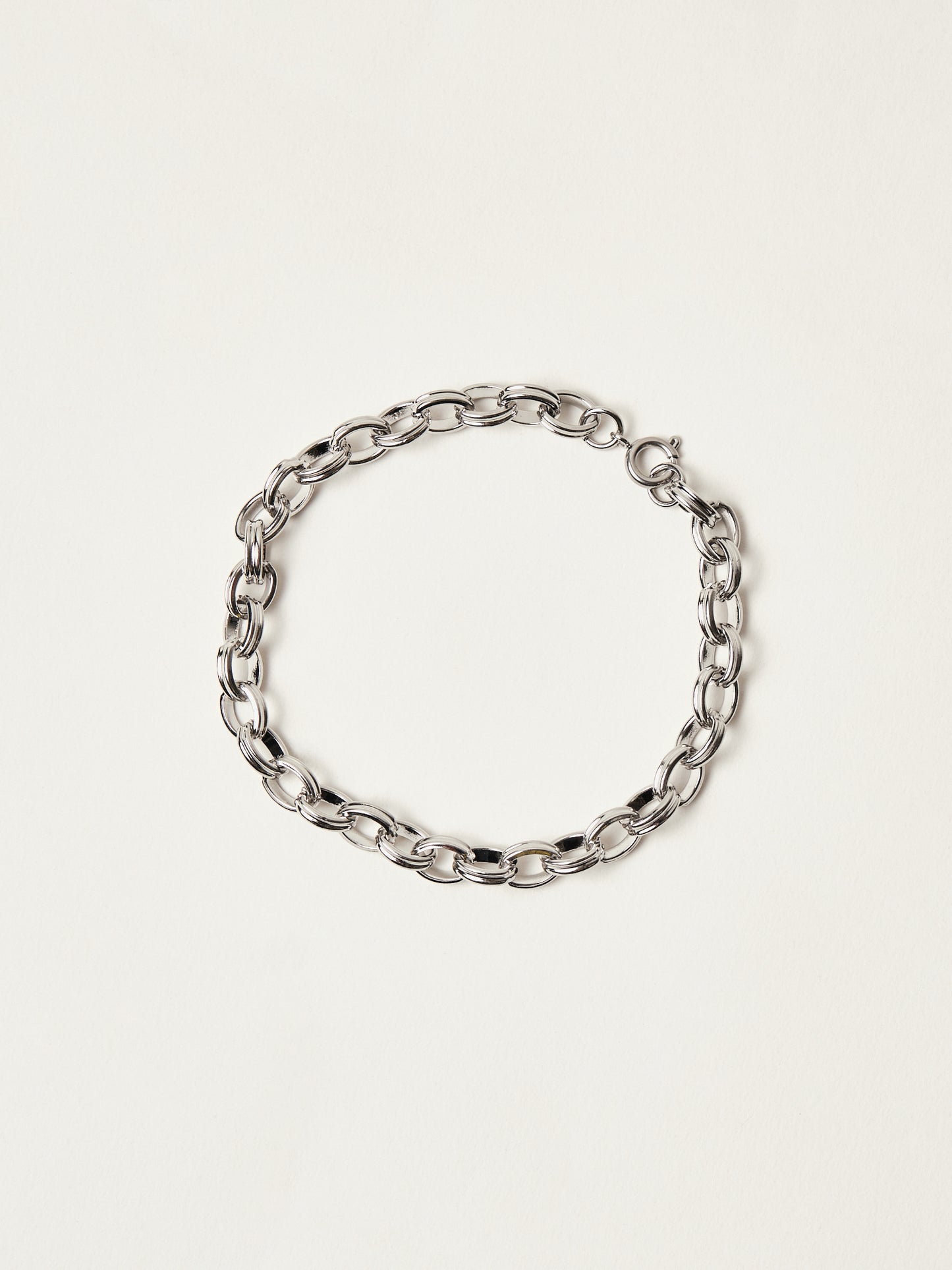 Silver chain bracelet on a light beige background