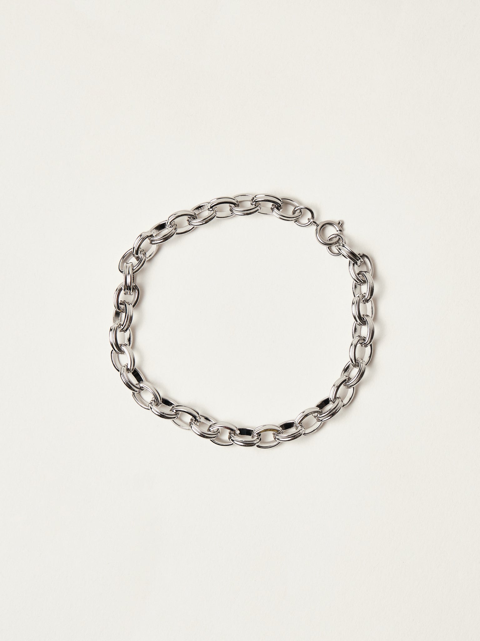 Silver chain bracelet on a light beige background