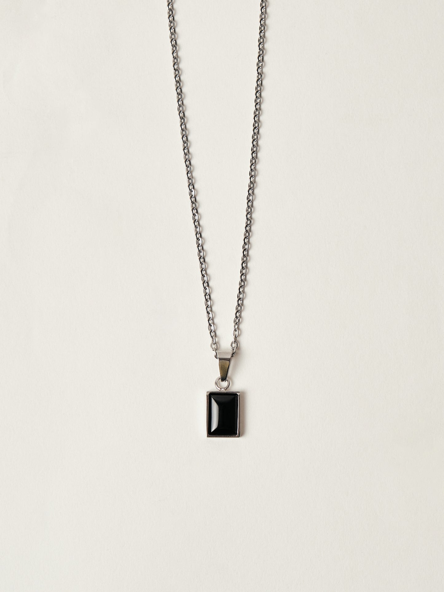 Necklace with a black pendant on a light gray background