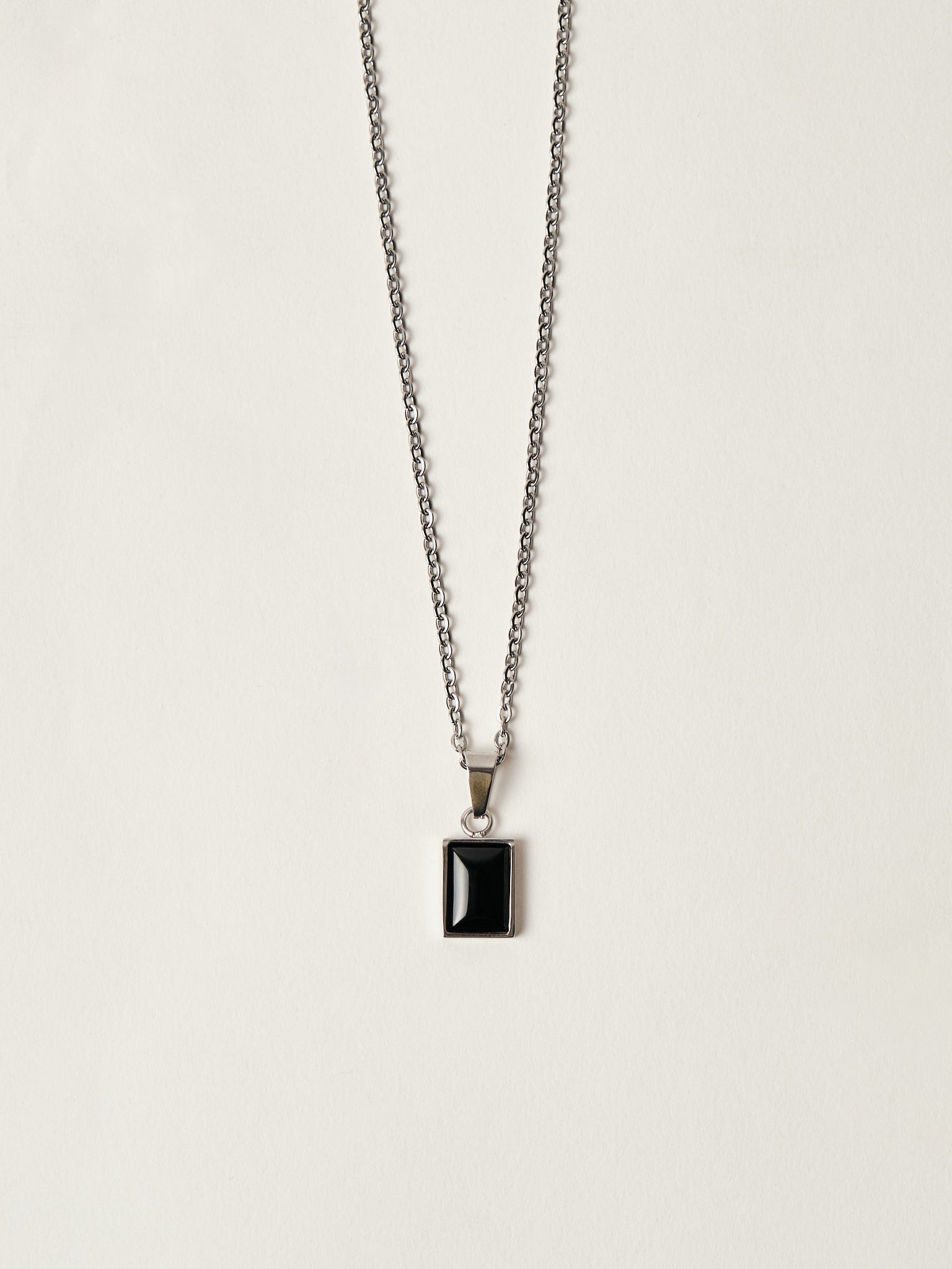 Necklace with a black pendant on a light gray background