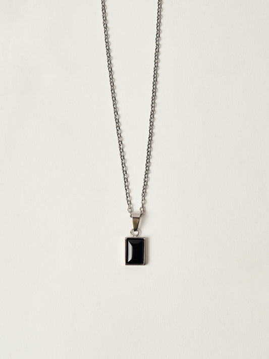 Necklace with a black pendant on a light gray background