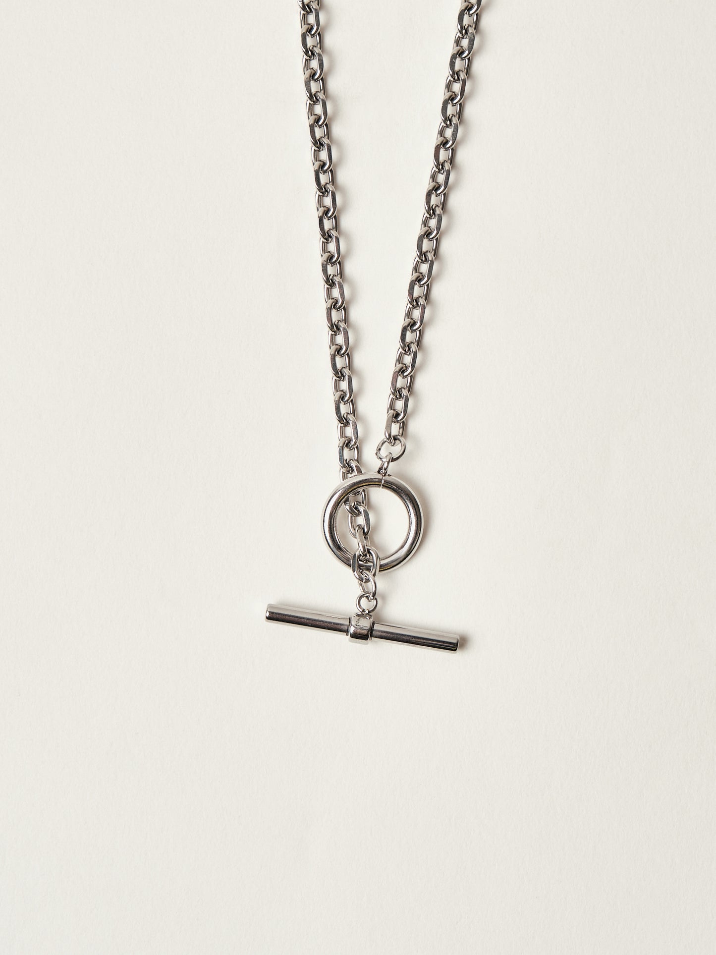 Silver necklace with a pendant on a light gray background