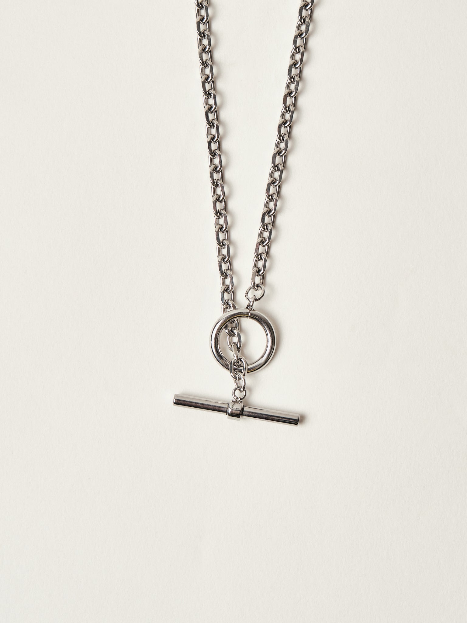 Silver necklace with a pendant on a light gray background