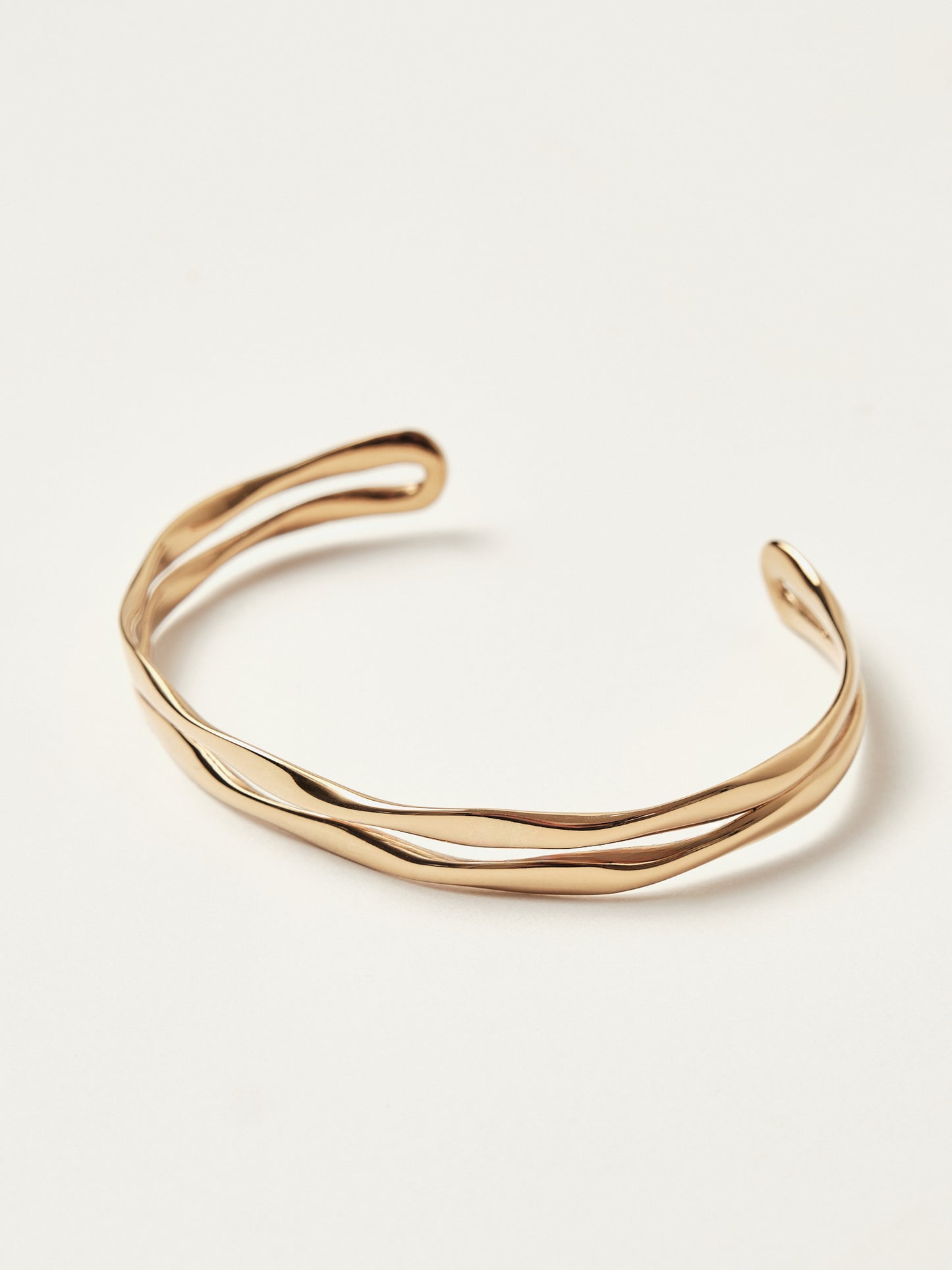 Gold bangle on a light beige background