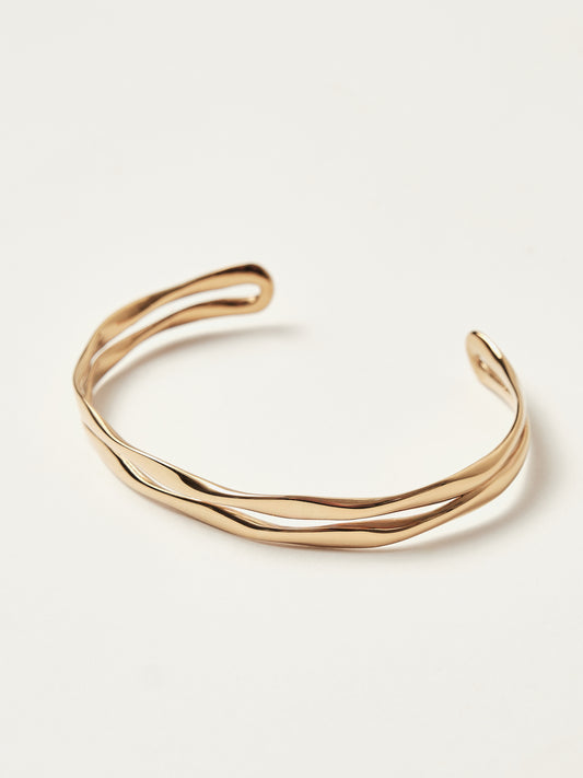 Gold bangle on a light beige background