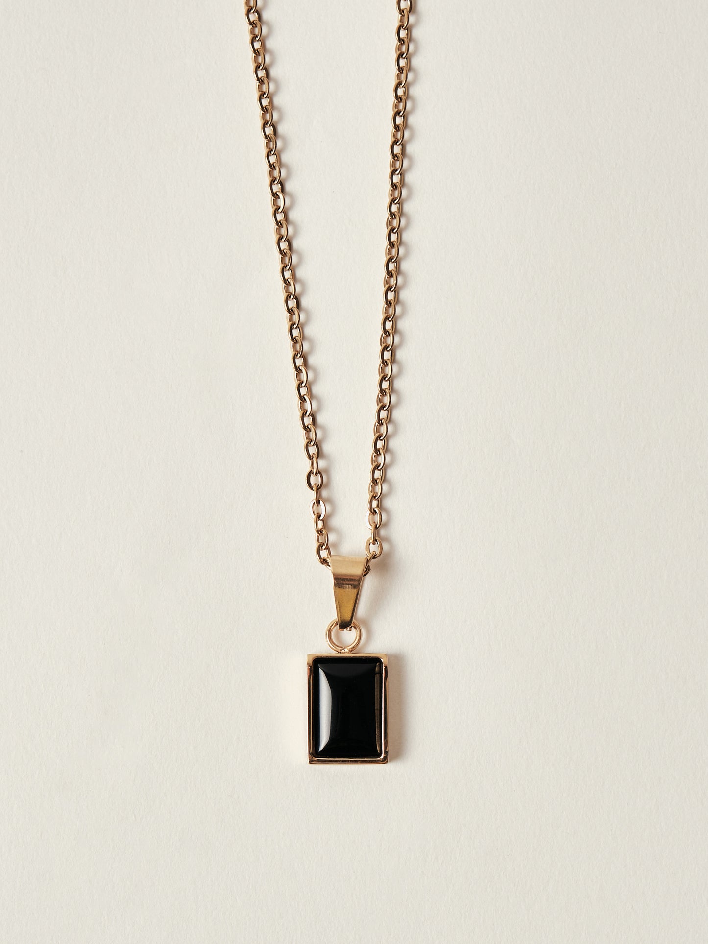 Necklace with a black pendant on a beige background