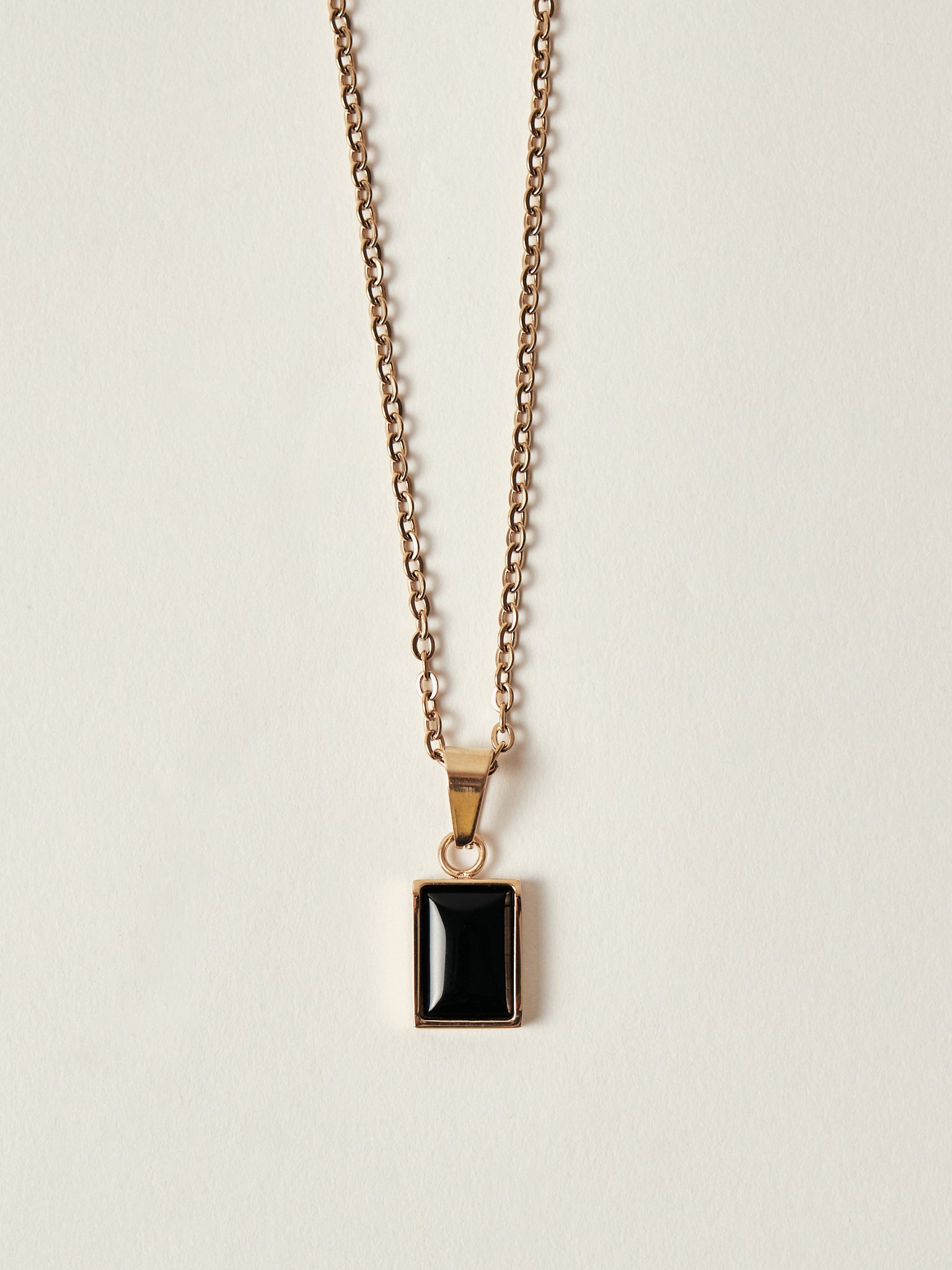 Necklace with a black pendant on a beige background