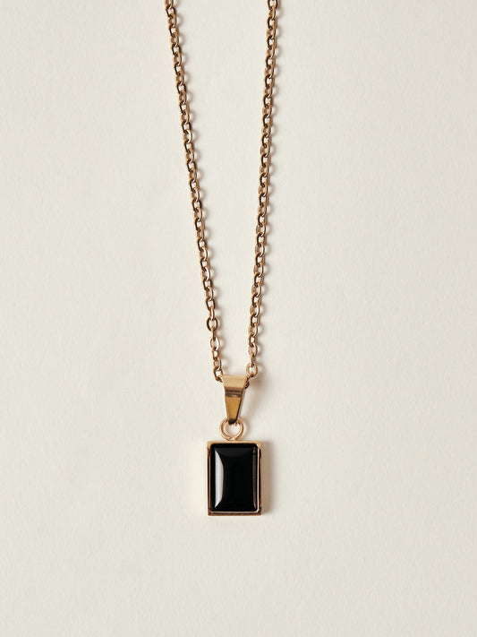 Necklace with a black pendant on a beige background