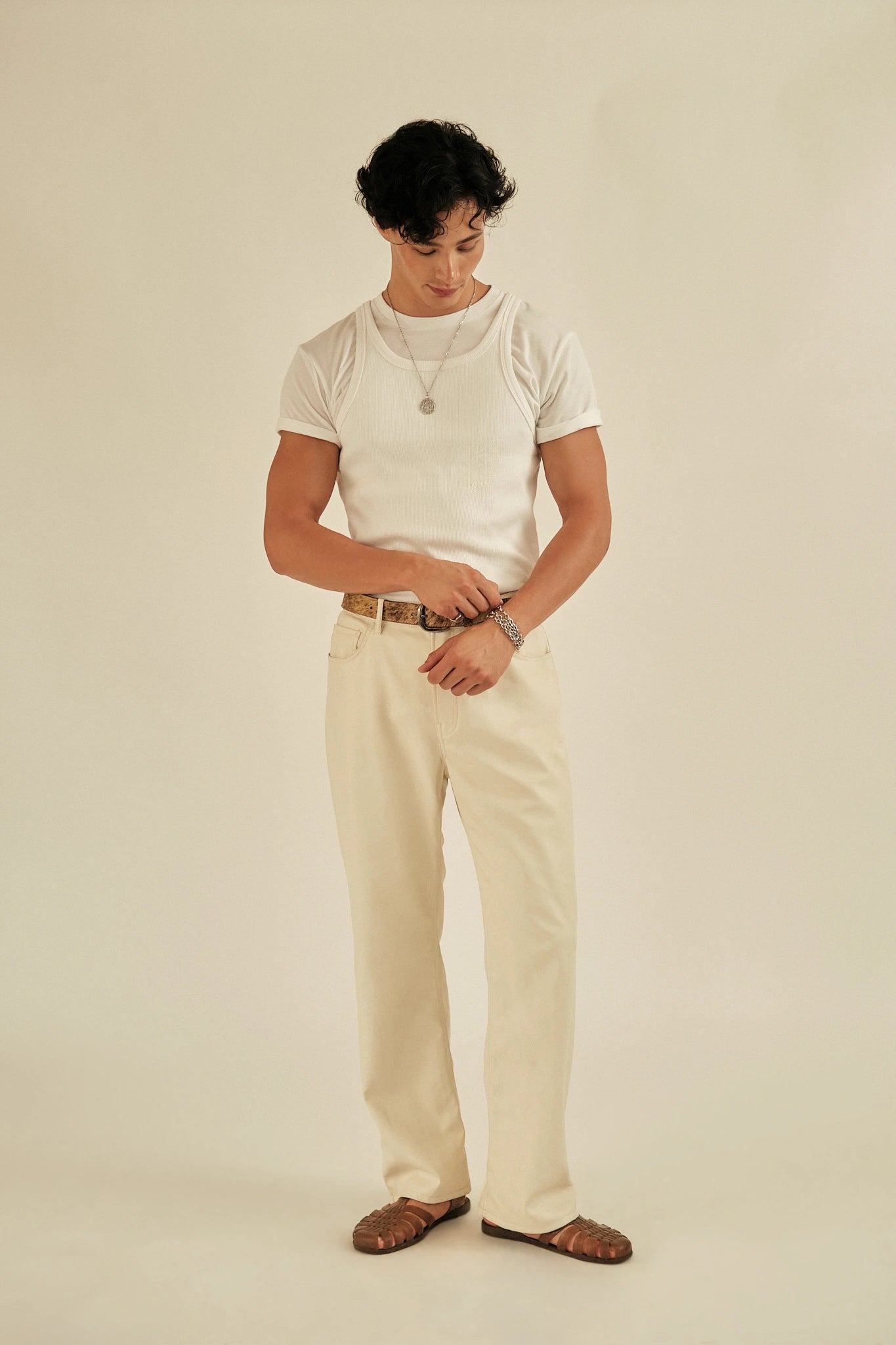 Person wearing a white t-shirt and beige pants on a plain background