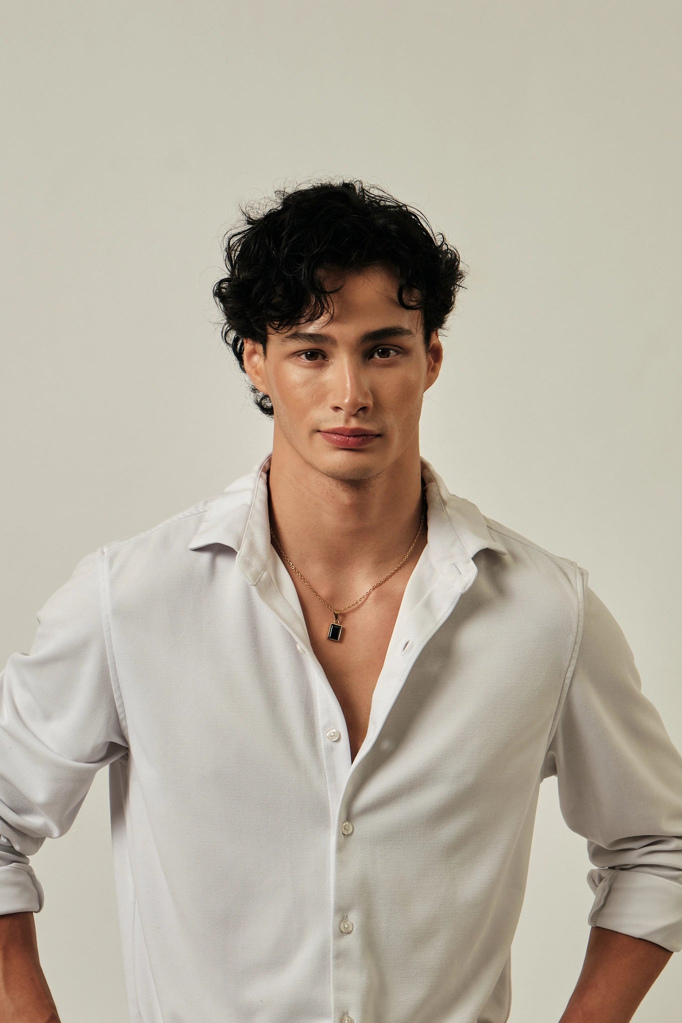 Man wearing a white shirt against a plain background