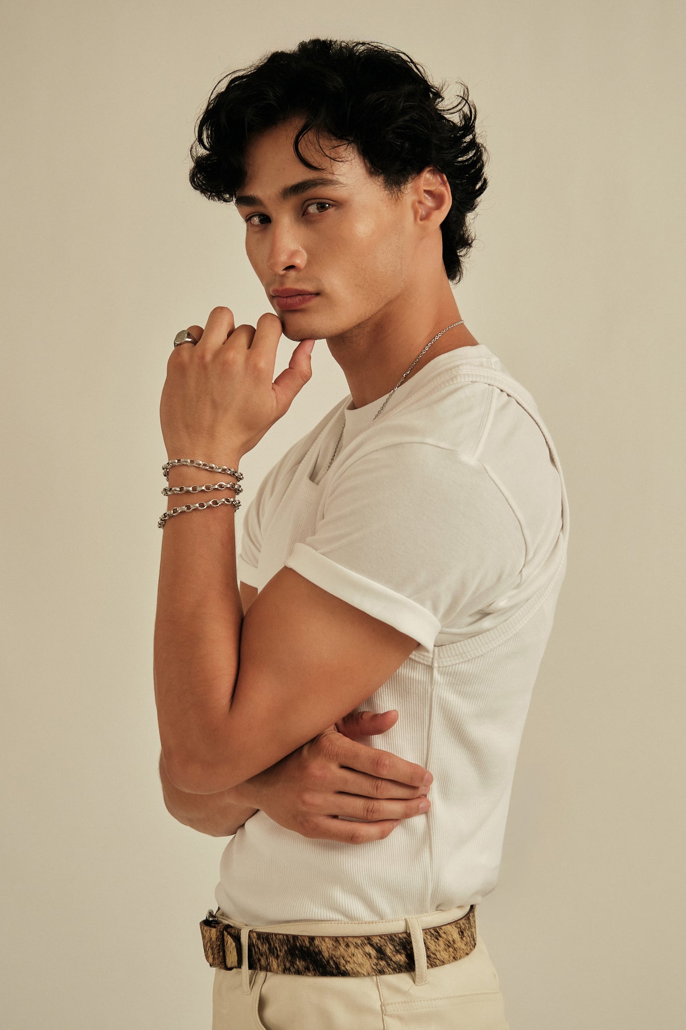 Man wearing a white t-shirt with a neutral background