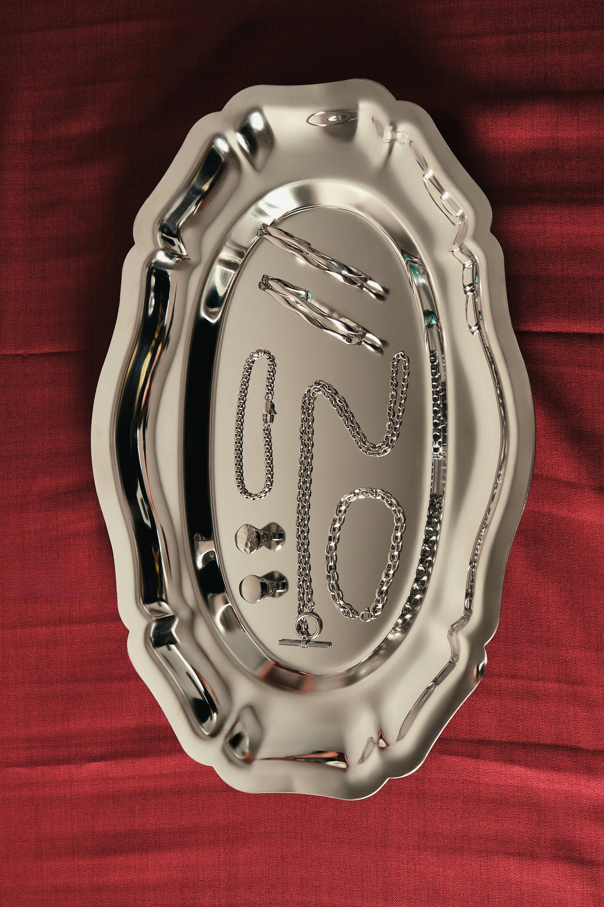 Silver decorative plate with embossed text on a red fabric background